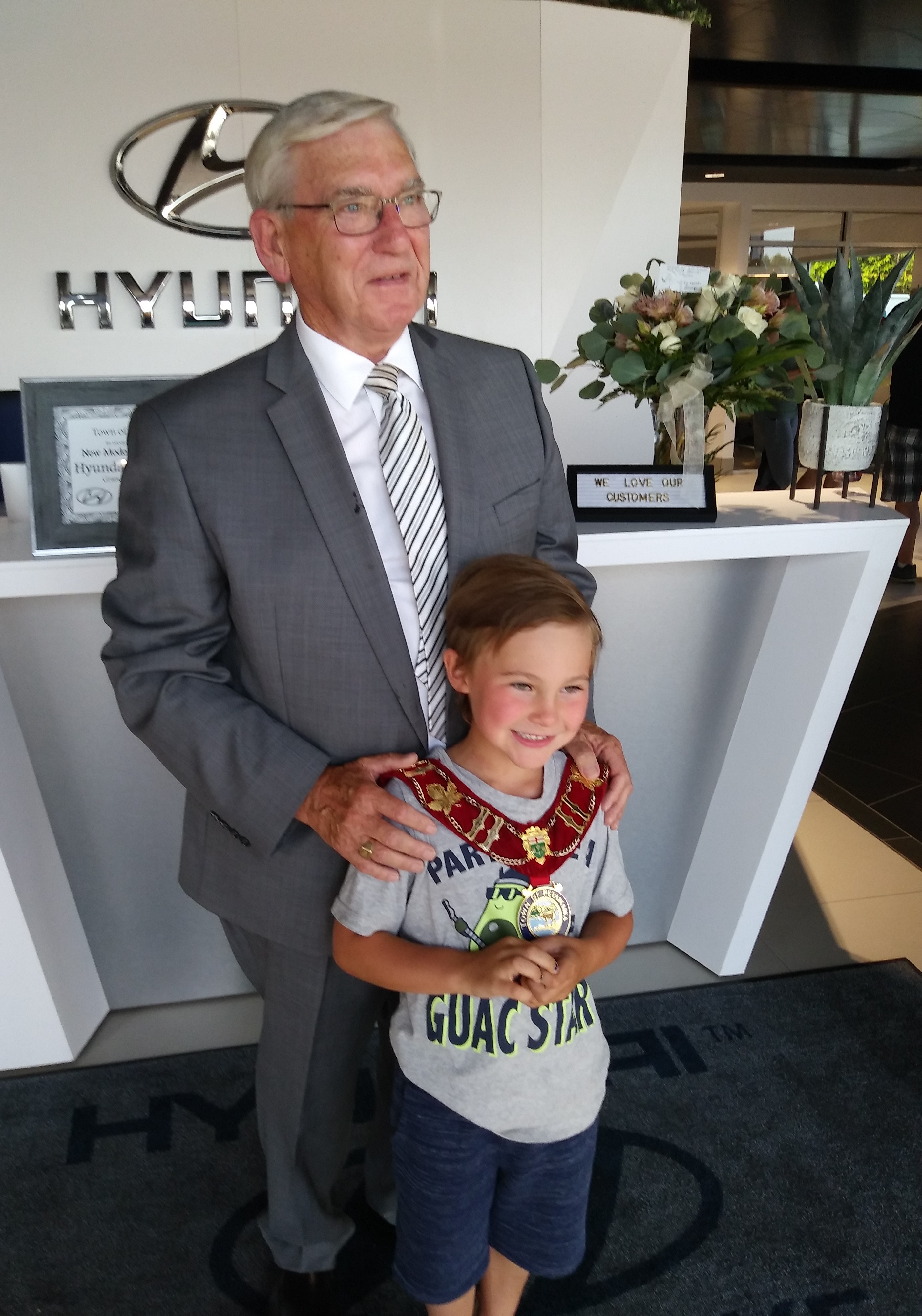 Mayor Sweet with young customer wearing the chain of office