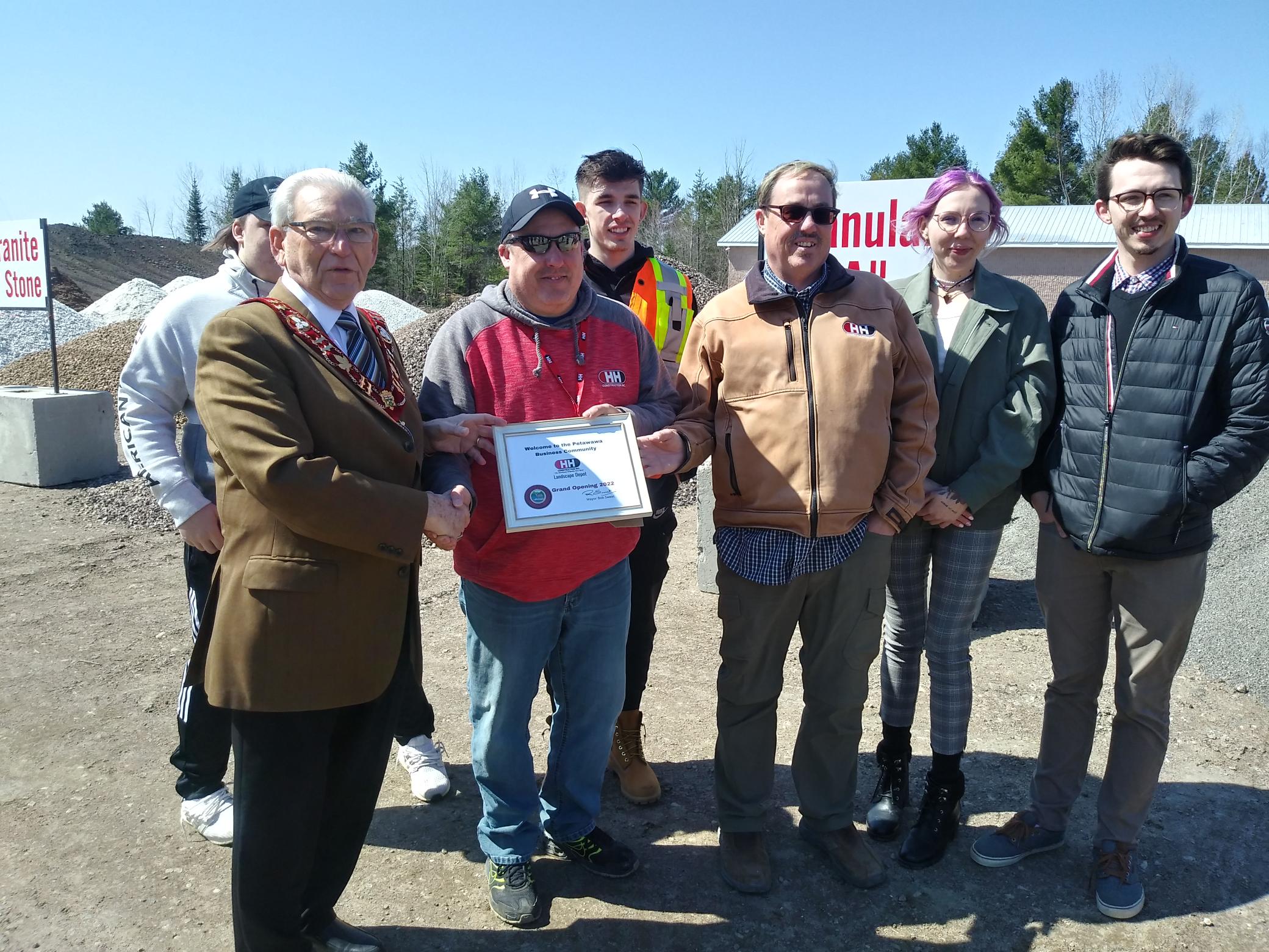 Certificate presentation from mayor to H&H Construction owners and their children