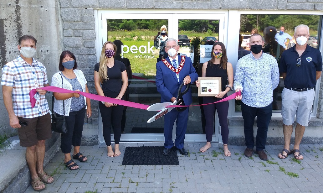 an outside image of multiple people conducting a ribbon cutting
